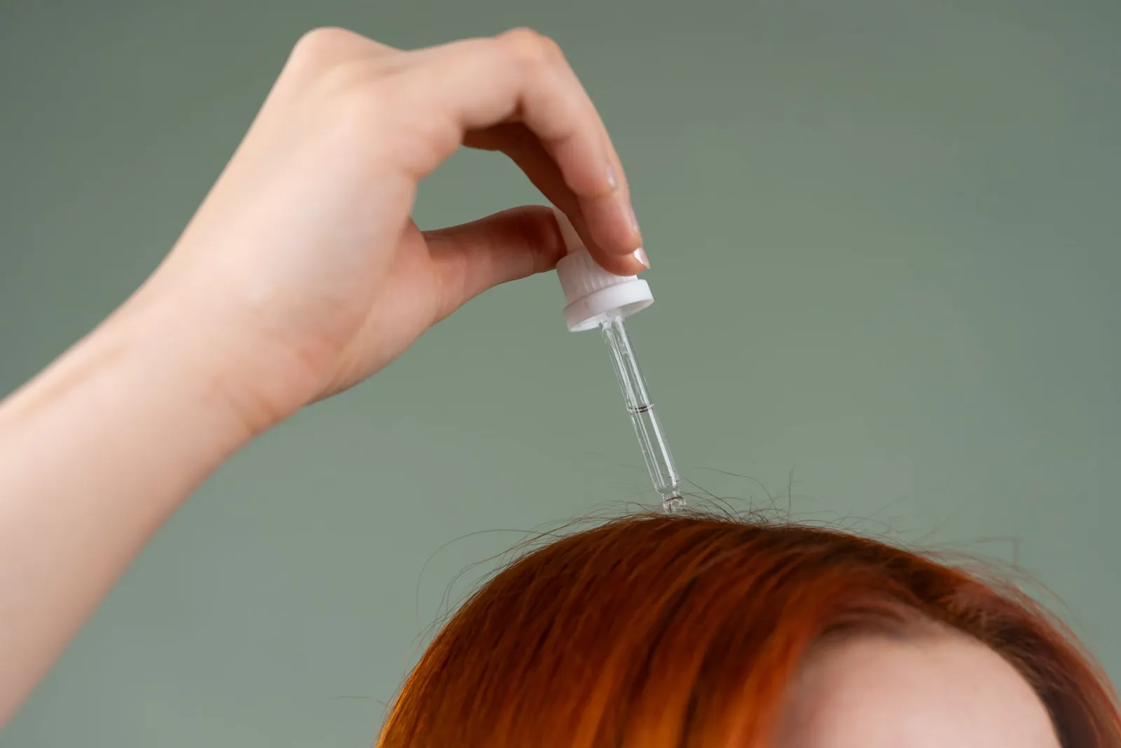 Hand som applicerar serum med pipett i en hårbena