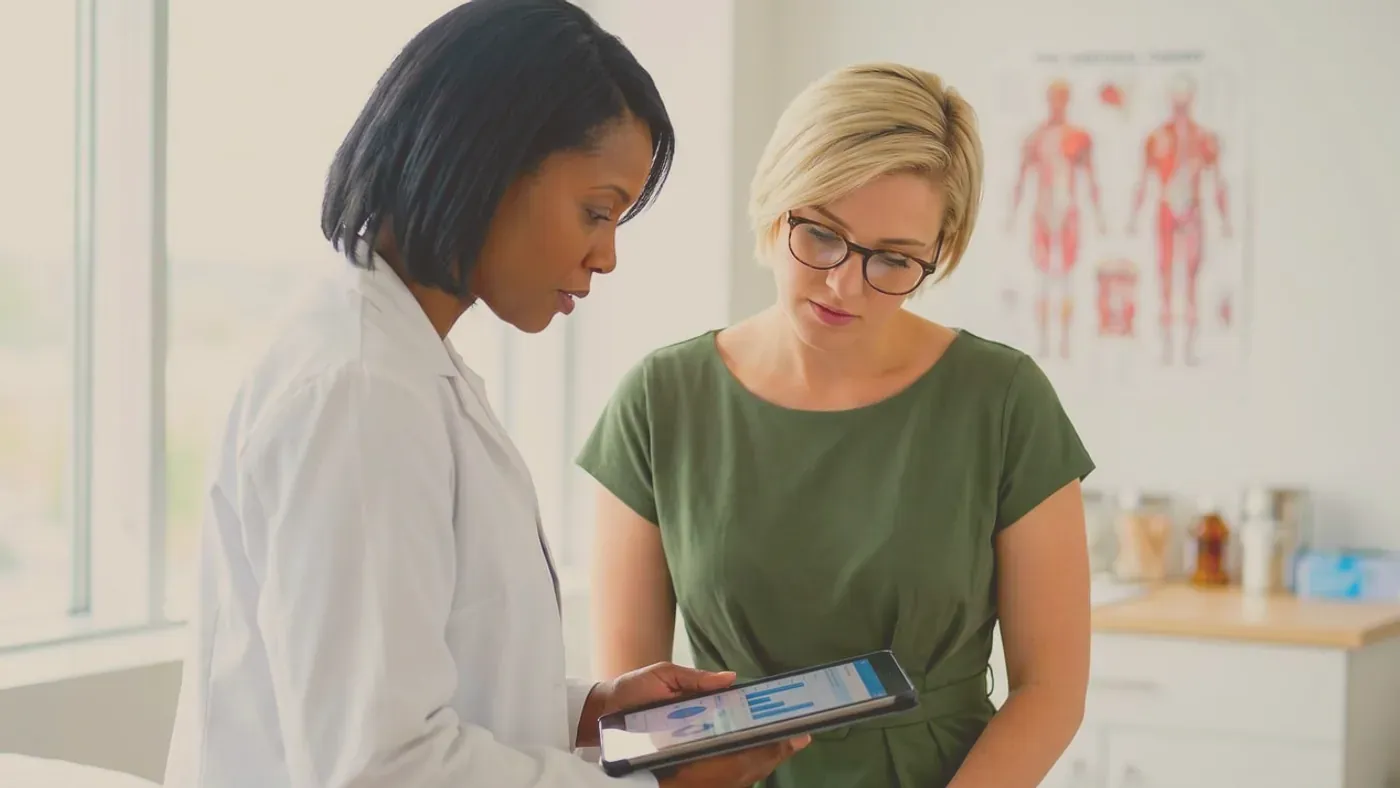 Läkare visar och förklarar data på en surfplatta för en patient